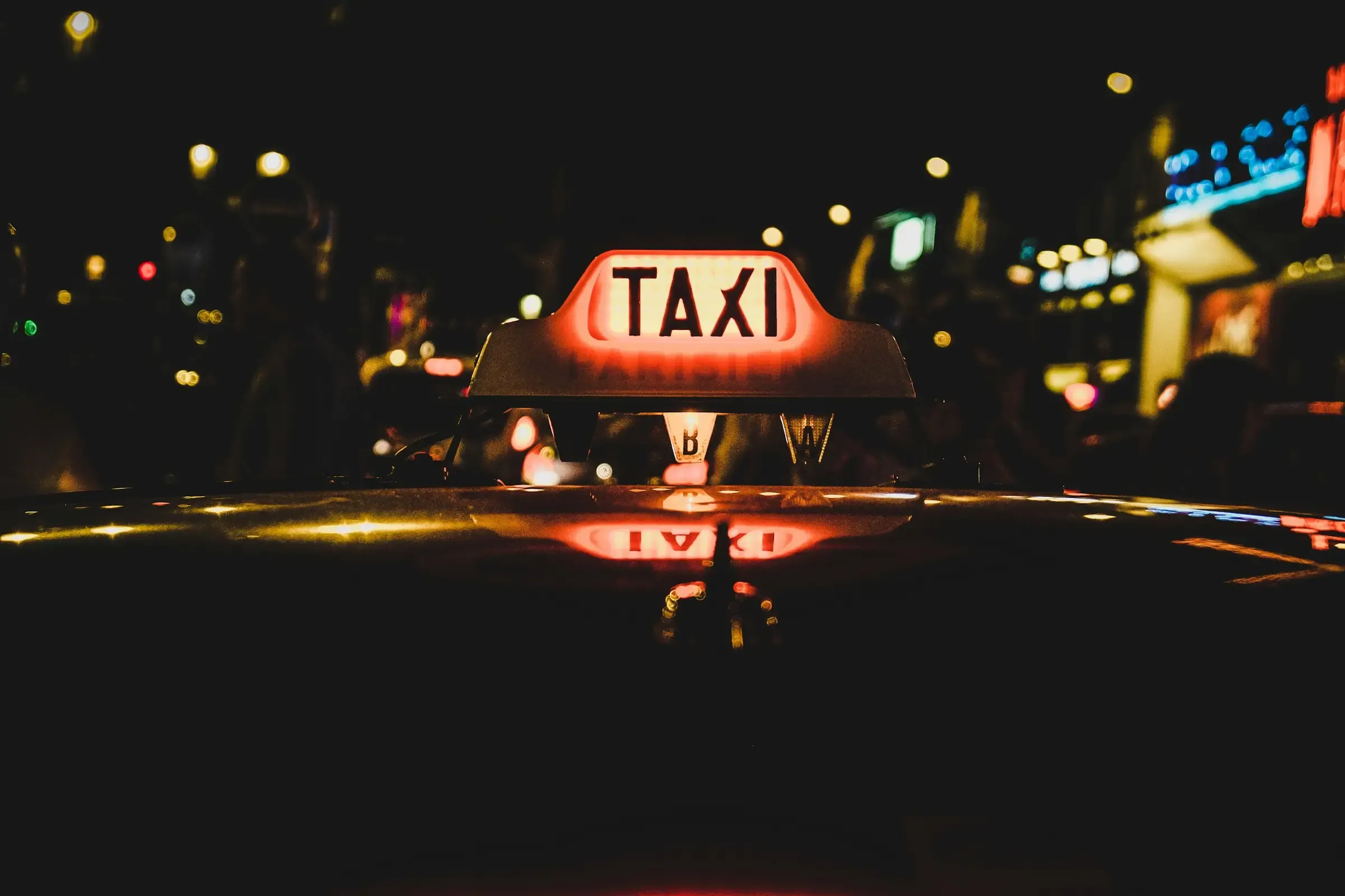 Enseigne lumineuse de taxi sur le toit d’un véhicule, de nuit
